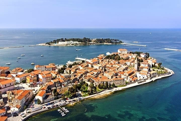 Aerial view of a coastal town with red-roofed buildings by the sea.