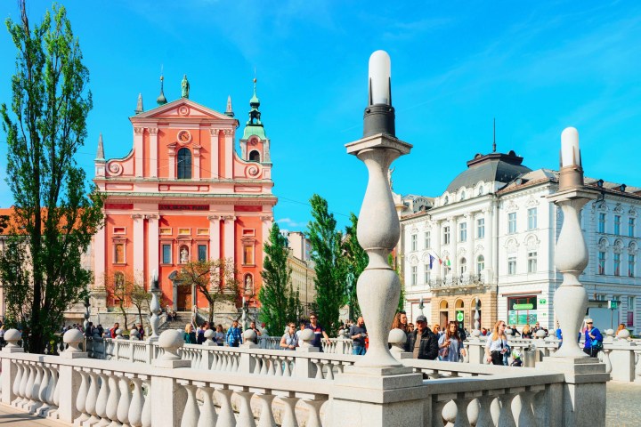 City square with pink church, people walking, and blue sky