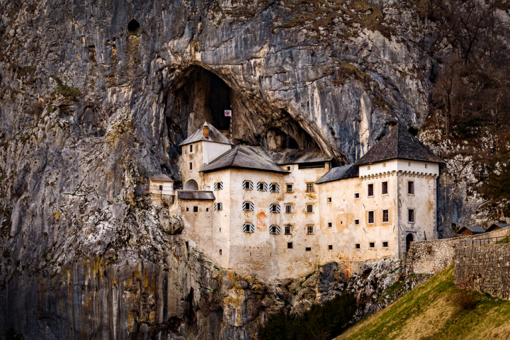 A castle built into a rocky cliff face.