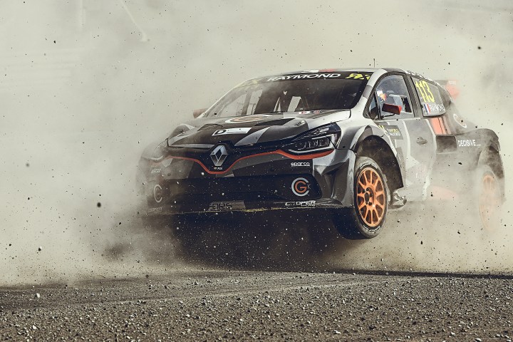 Rally car in action on a dusty track, lifting front wheels off the ground.